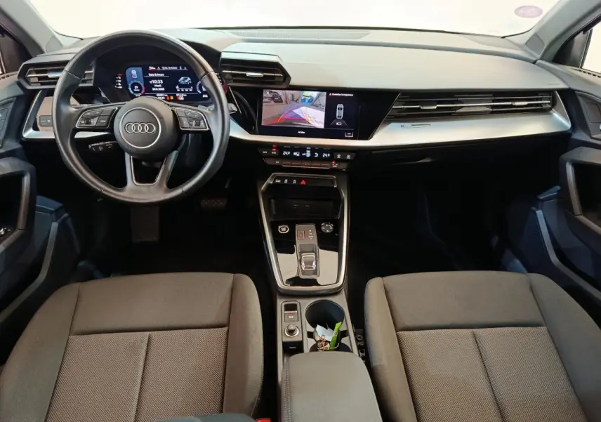 Intérieur Audi A3 30 TFSI MHEV 2022 vu de face, tableau de bord noir avec écran tactile et volant cuir multifonctions.