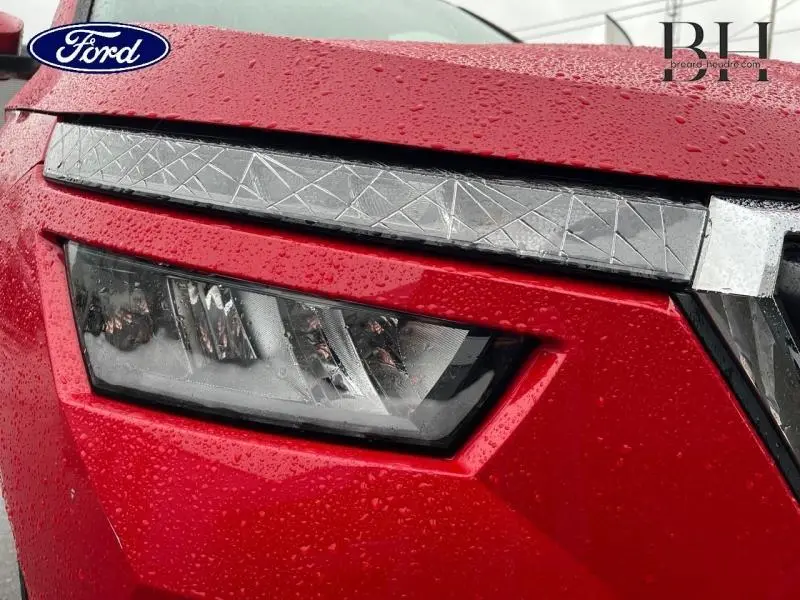 Gros plan sur le phare avant gauche rouge Velvet métallisé du Skoda Kamiq 2022 avec détails géométriques sur la calandre.