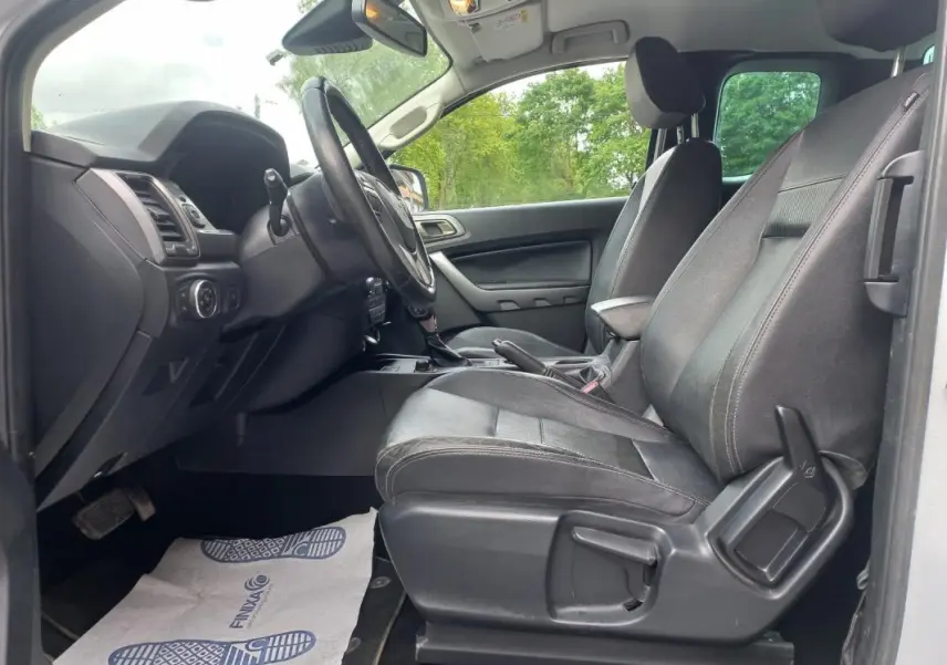 Vue intérieure côté conducteur du Ford Ranger Super Cabine Limited 2022, sièges noirs et tableau de bord visible.
