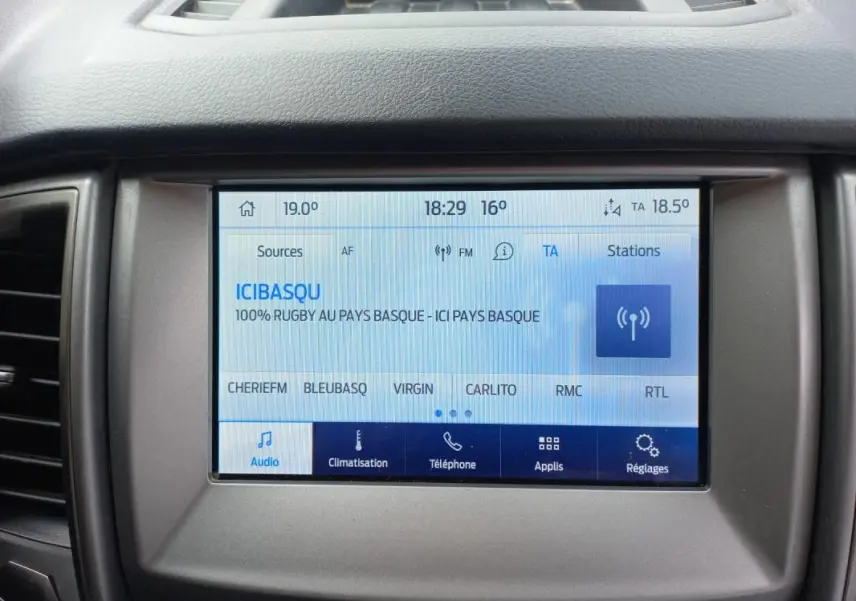Écran tactile central du Ford Ranger blanc 2022 affichant la radio et les options de climatisation et téléphone.