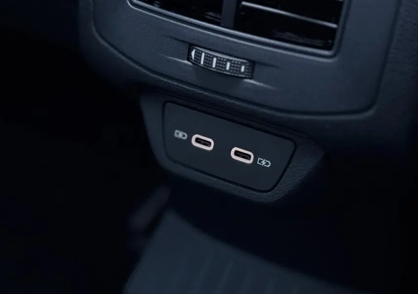 Gros plan sur les deux ports USB-C arrière du Volkswagen T-Roc gris pyrite 2025 avec finition R-Line.