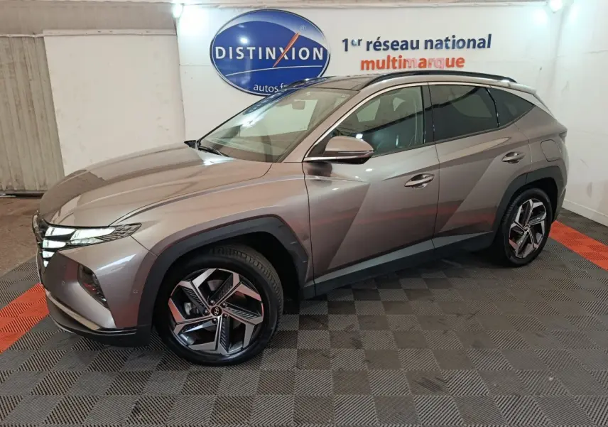 Vue 3/4 avant droit du Hyundai Tucson marron 2022 hybride rechargeable avec jantes modernes et lignes anguleuses.