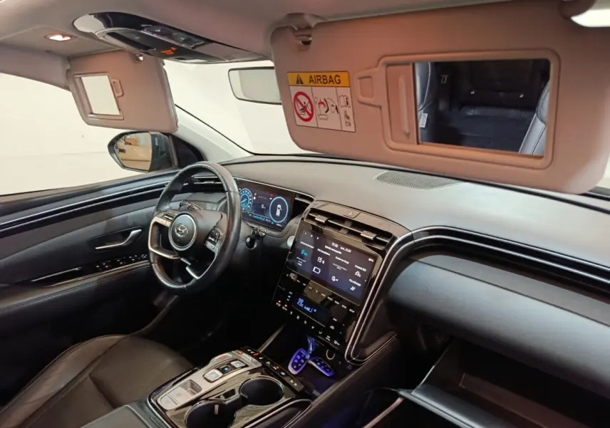 Intérieur du Hyundai Tucson 2022 vu côté conducteur, tableau de bord numérique et écran tactile central noir.