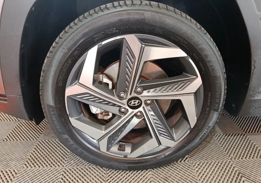 Gros plan sur la roue avant droite marron du Hyundai Tucson 1.6 PHEV 265 HTRAC avec jante alliage design moderne.