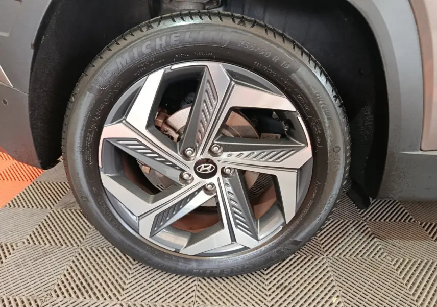 Gros plan sur la jante alliage moderne avec logo Hyundai du côté avant droit du Tucson marron 2022.