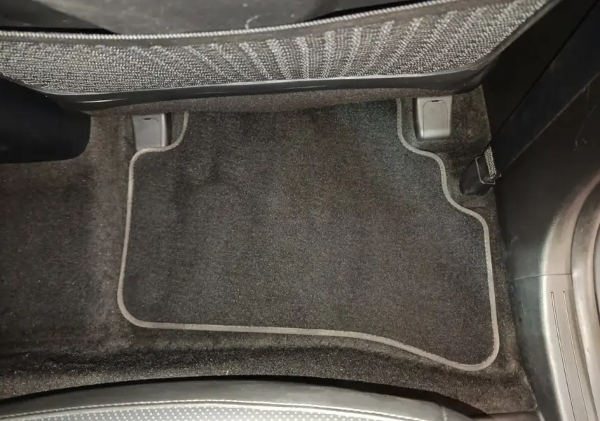 Tapis de sol noir côté passager arrière du Hyundai Tucson 1.6 PHEV marron, vue intérieure rapprochée.