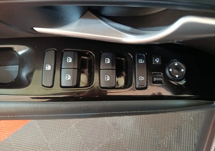 Gros plan sur la commande des vitres et rétroviseurs côté conducteur du Hyundai Tucson marron 2022.