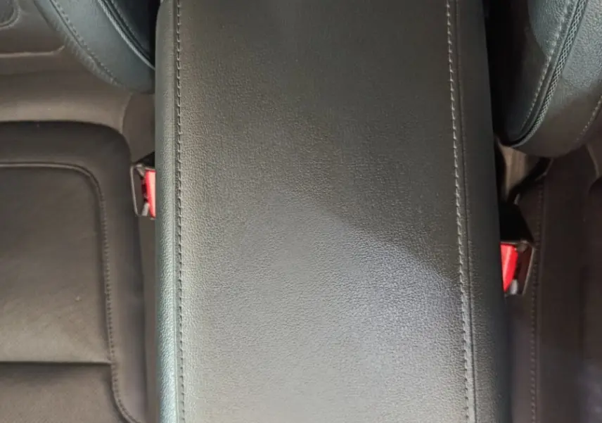 Vue plongeante sur l'accoudoir central en cuir noir de l'habitacle du Hyundai Tucson marron 2022 hybride rechargeable.