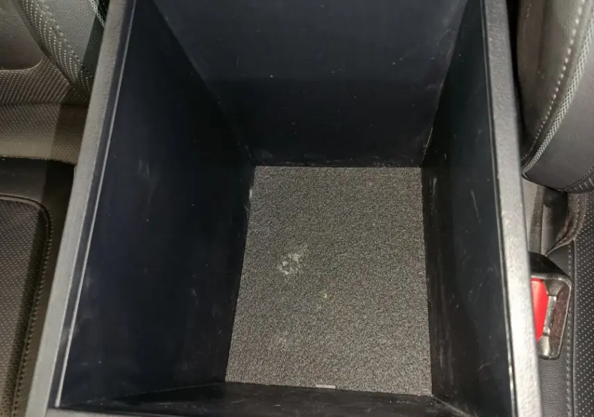 Vue rapprochée de la console centrale noire ouverte du Hyundai Tucson 2022, montrant le rangement intérieur vide.