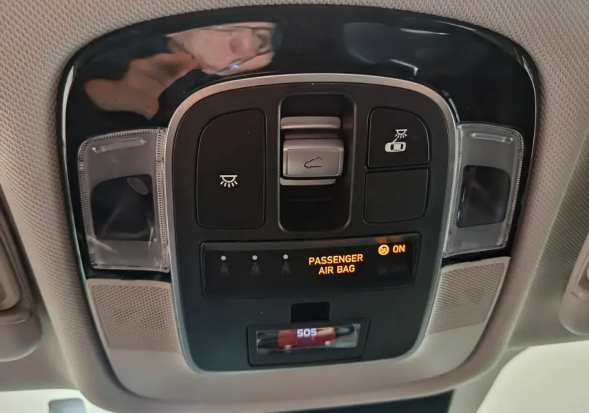 Vue en gros plan du panneau de commandes au plafond du Hyundai Tucson marron 2022, avec indicateur airbag passager allumé.