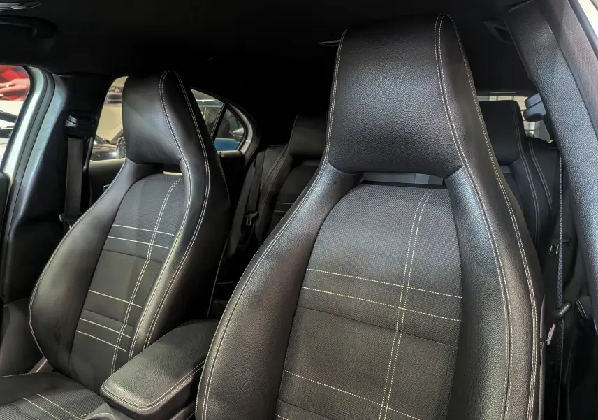 Gros plan sur les sièges avant en cuir noir avec surpiqûres blanches de la Mercedes Classe A 200d 2016.