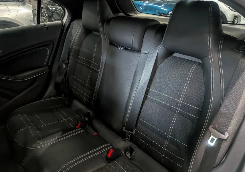 Vue intérieure des sièges arrière en cuir noir avec surpiqûres blanches d'une Mercedes Classe A 200d 2016.