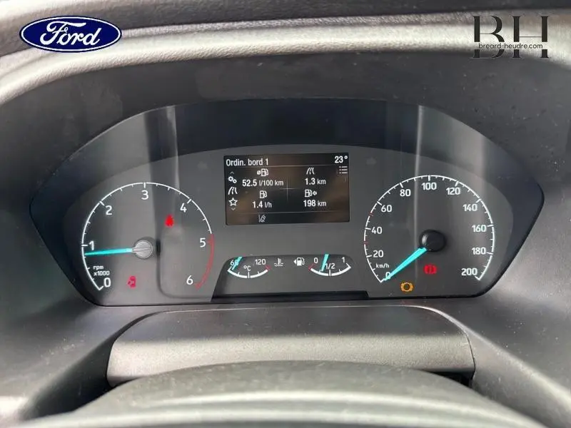 Vue rapprochée du tableau de bord numérique du Ford Transit Custom 2023, affichant les compteurs et l'ordinateur de bord.