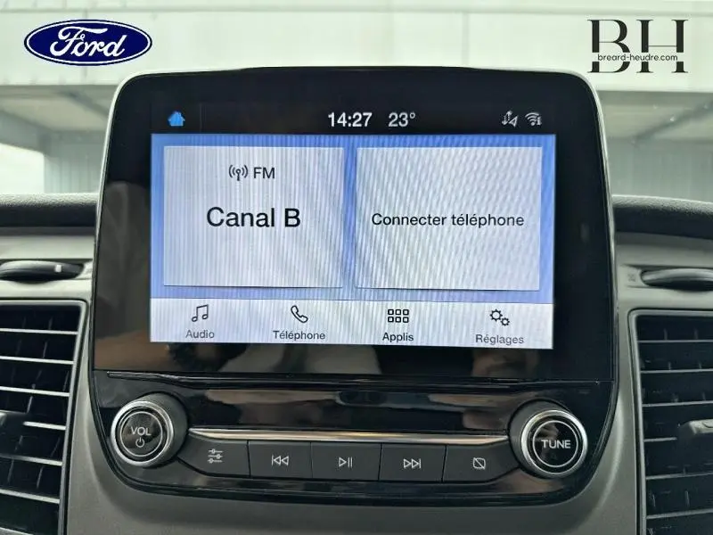 Écran tactile central du Ford Transit Custom 2023 affichant la radio FM Canal B et les options de connexion téléphone.