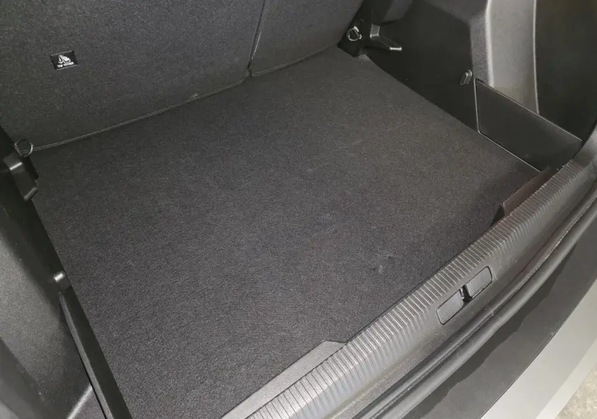 Vue plongeante sur le coffre spacieux et propre du Peugeot 2008 gris métallisé, avec seuil de coffre gris météor.