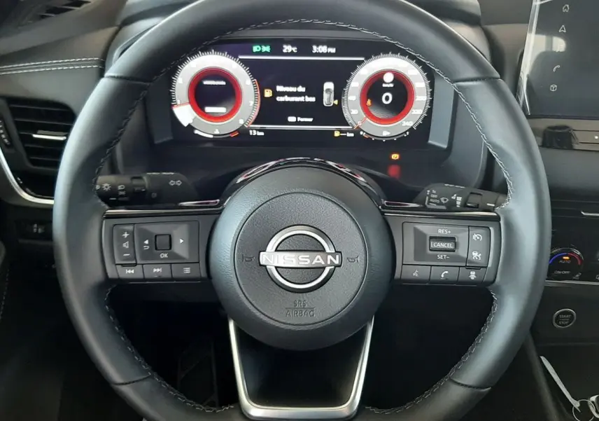 Vue rapprochée du volant noir du Nissan Qashqai 2022 avec tableau de bord numérique et commandes intégrées.