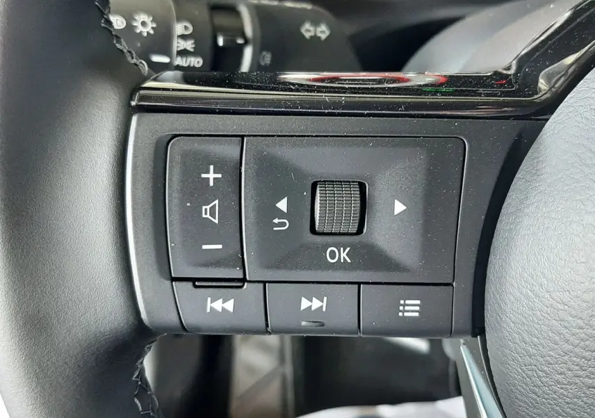 Gros plan sur les commandes noires du volant du Nissan Qashqai blanc lunaire 2022, version N-Connecta.