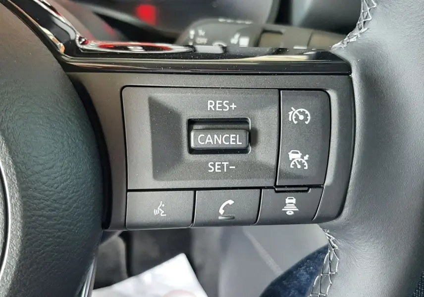 Gros plan sur les commandes au volant du Nissan Qashqai blanc lunaire 2022, version N-Connecta mild hybrid.