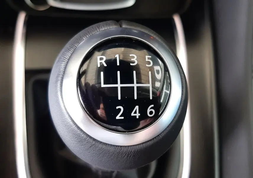 Gros plan sur le levier de vitesses manuel noir et argent du Nissan Qashqai blanc lunaire 2022.