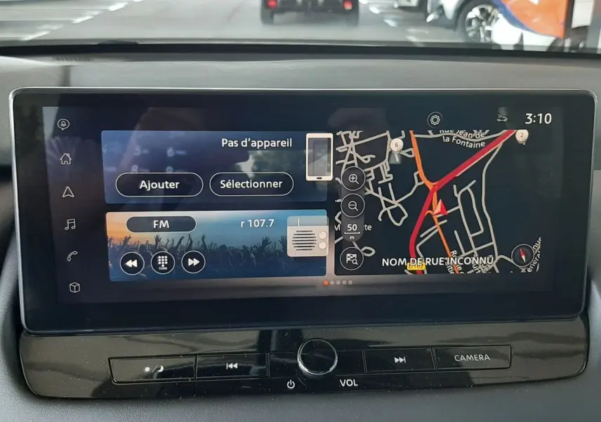 Écran tactile central du Nissan Qashqai blanc lunaire 2022 affichant navigation et radio FM, vue intérieure avant.