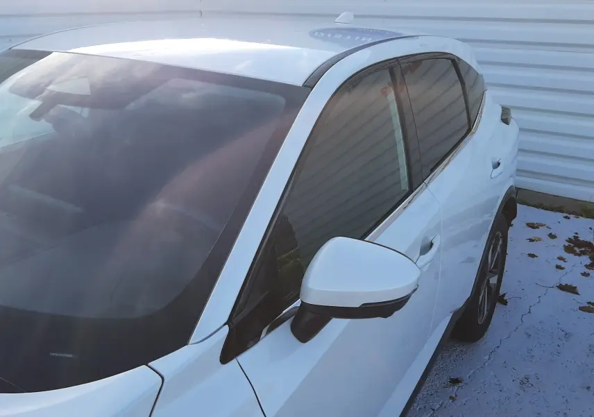 Vue 3/4 avant droit du Nissan Qashqai blanc lunaire 2022 avec rétroviseur et vitres teintées visibles.