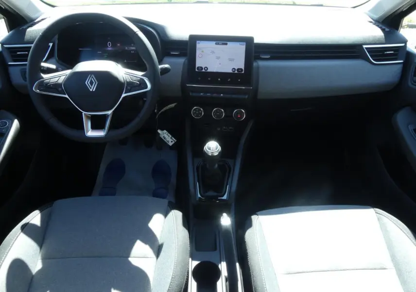 Vue intérieure avant de la Renault Clio 2025 montrant le volant multifonction, levier de vitesse manuel et écran tactile 7 pouces.