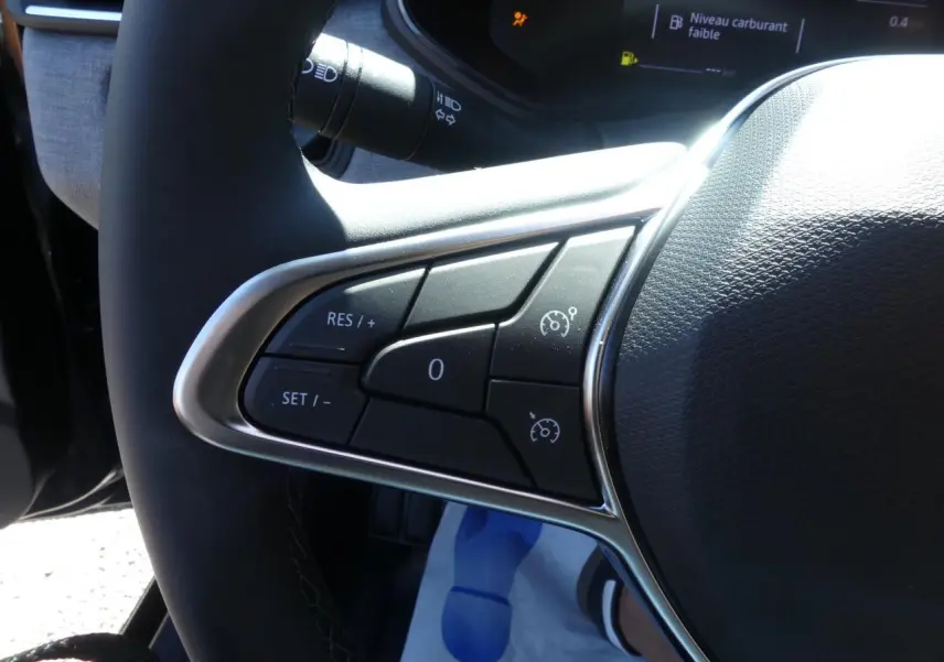 Gros plan sur les commandes de régulateur de vitesse au volant de la Renault Clio 1.5 Blue dCi noir métallisé 2025