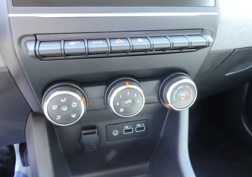 Gros plan sur les commandes de climatisation et boutons de fonction du tableau de bord de la Renault Clio noire 2025.