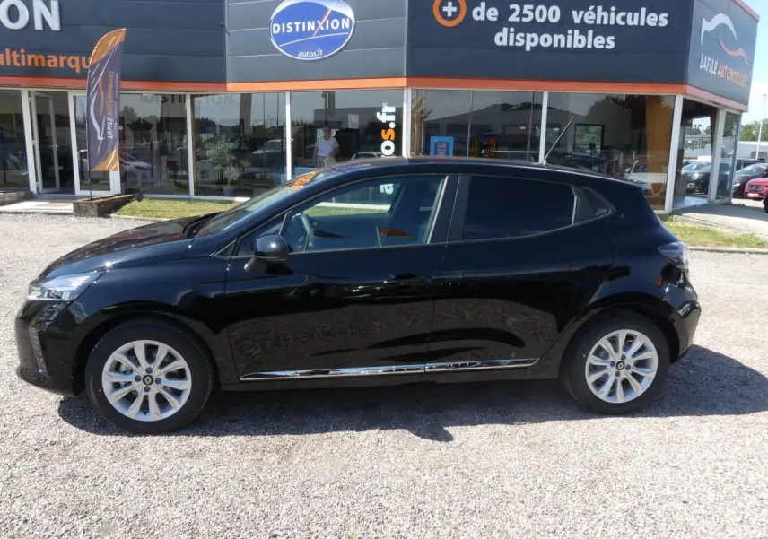 Profil côté gauche d'une Renault Clio noire métallisée avec jantes alliage et baguettes chromées visibles.