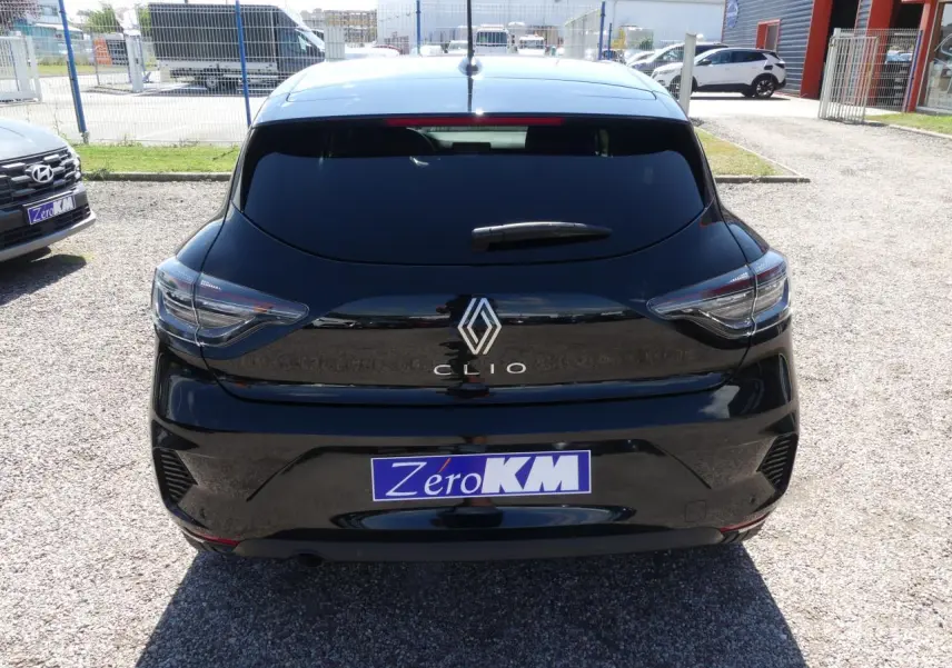 Vue arrière d'une Renault Clio noire métallisée 2025 avec feux arrière LED et logo Renault chromé visible.