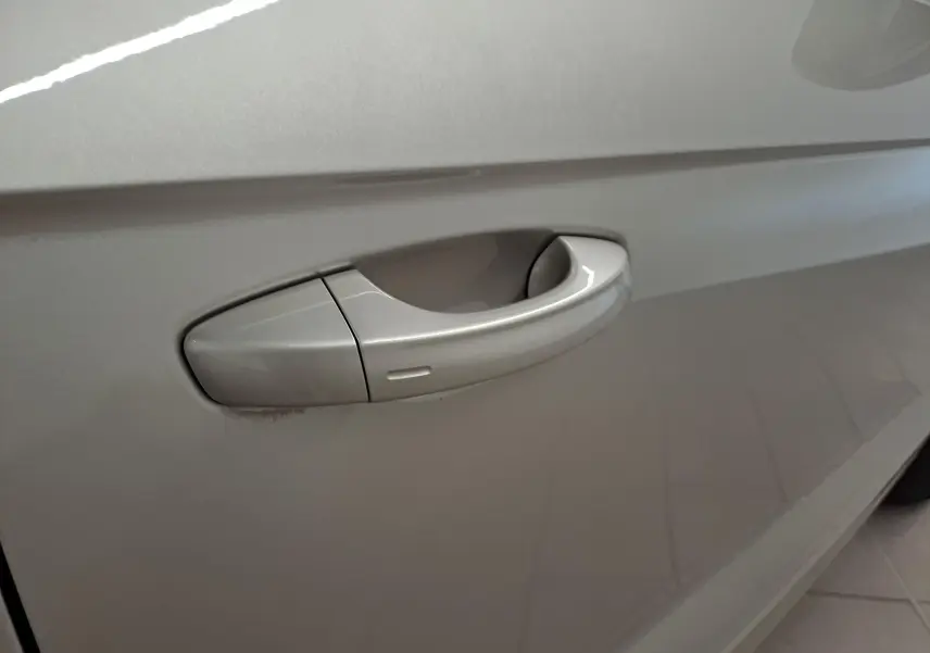 Poignée de porte gris ivoire du côté gauche d'un Volkswagen T-Roc Cabriolet 2022 avec peinture métallisée.