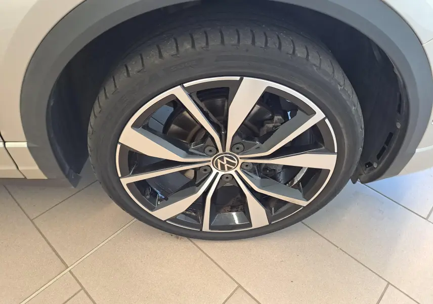 Gros plan sur la jante alliage 19'' Misano noir et argent du côté avant droit du Volkswagen T-Roc Cabriolet gris ivoire.