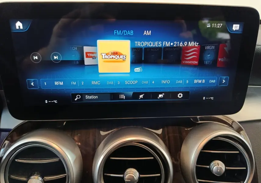 Écran tactile multimédia affichant la radio FM dans l'habitacle d'une Mercedes GLC 300 e Business Line noire.