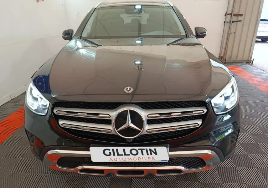 Vue frontale d'un Mercedes GLC 300 e Business Line 4Matic noir avec calandre chromée et phares LED allumés.