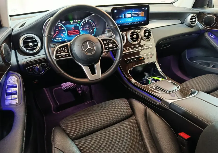 Intérieur noir du Mercedes GLC 300 e Business Line 2020, vue du poste de conduite avec écran tactile et volant multifonctions.