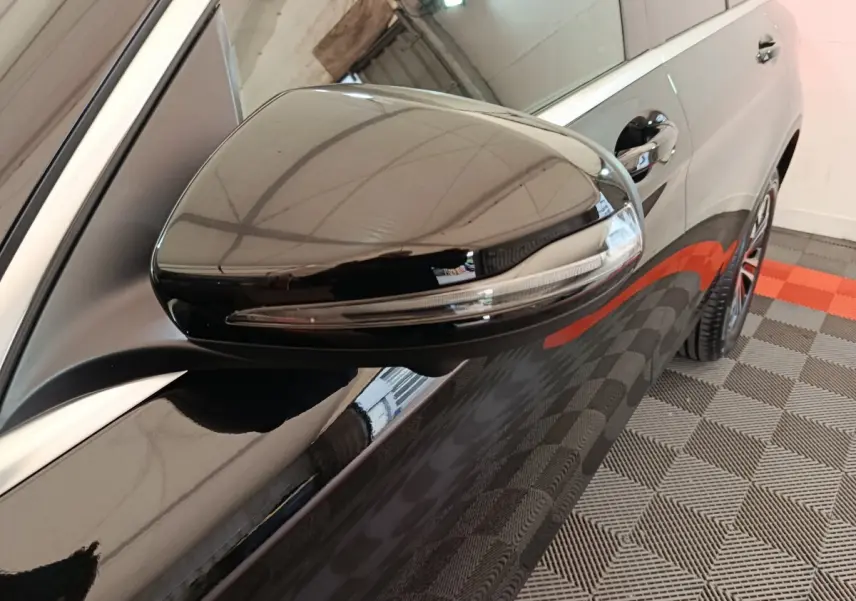 Gros plan sur le rétroviseur noir brillant côté gauche du Mercedes GLC 300 e Business Line 4Matic noir.