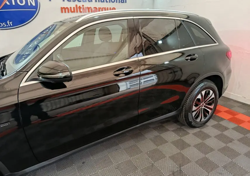 Profil côté gauche d'un Mercedes GLC 300 e Business Line noir, avec jantes alliage et rétroviseur électrique.