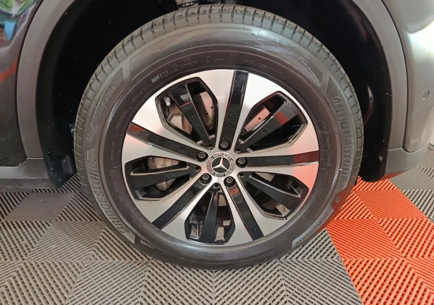 Gros plan sur la roue avant droite du Mercedes GLC 300 e Business Line noir avec jante alliage bicolore.