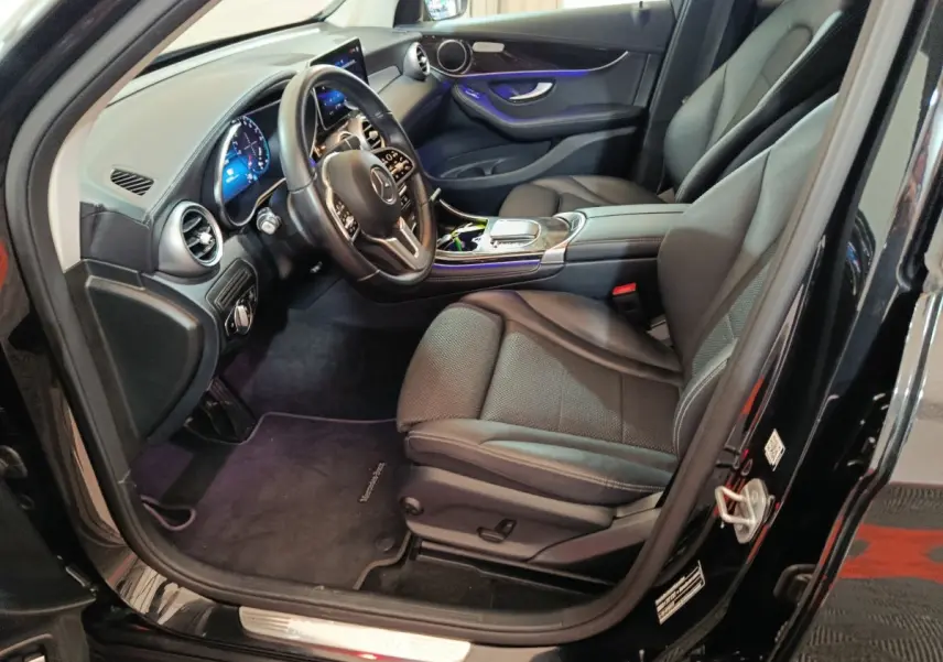 Intérieur côté conducteur d'une Mercedes GLC 300 e Business Line noire, avec tableau de bord numérique et sellerie cuir noire.