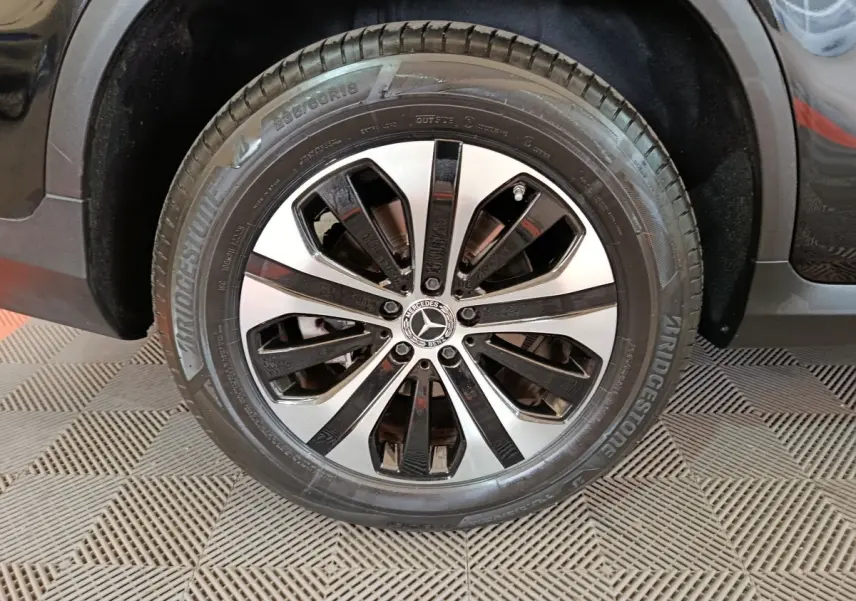 Gros plan sur la roue avant droite du Mercedes GLC 300 e Business Line noir avec jante alliage bicolore.