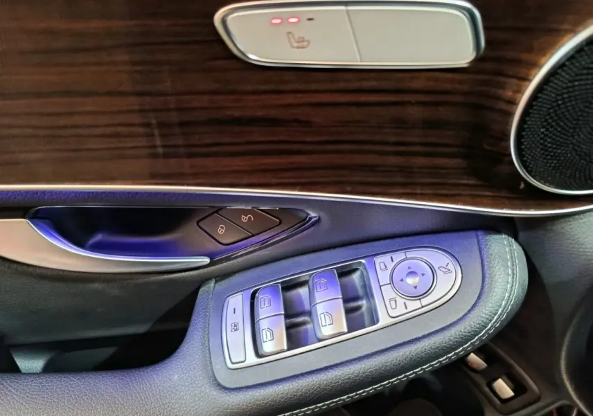 Détail de la porte côté conducteur du Mercedes GLC 300 e Business Line 2020 avec commandes alu et garniture bois foncé.