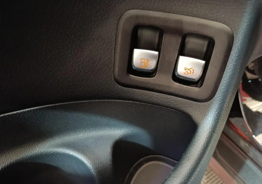 Gros plan sur les boutons d'ouverture du réservoir et du coffre dans l'habitacle noir du Mercedes GLC 300 e Business Line.