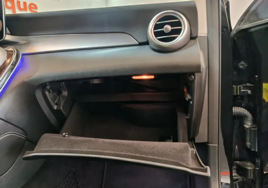 Vue intérieure côté passager du coffre à gants ouvert du Mercedes GLC 300 e Business Line noir de 2020.