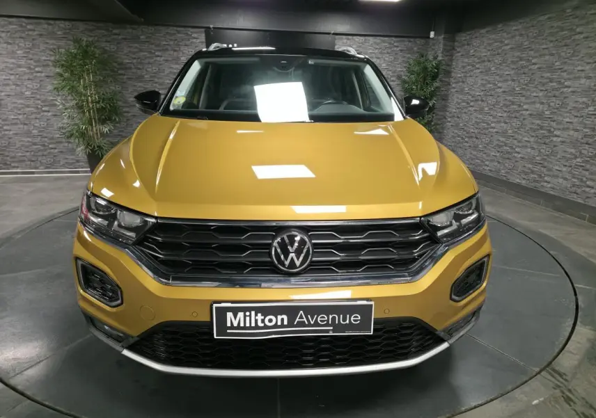 Vue frontale d'un Volkswagen T-Roc 2021 jaune curcuma avec calandre noire et toit contrastant noir.