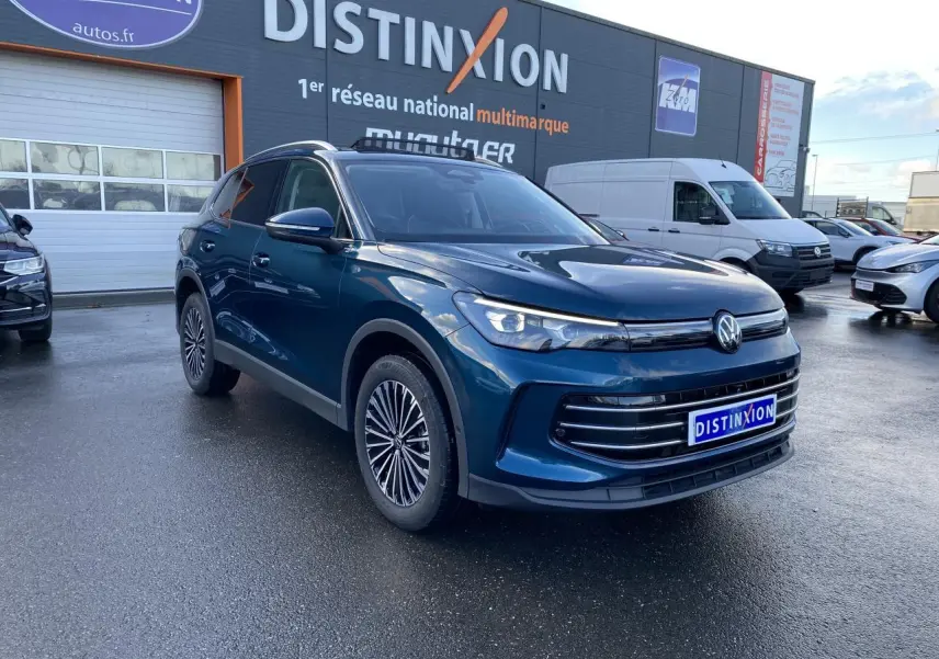 Volkswagen Tiguan 1.5 eHybrid bleu Nightshade en 3/4 avant droit avec phares LED et jantes stylisées.