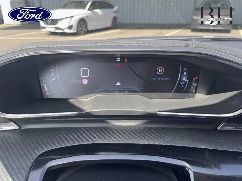 Tableau de bord numérique de Peugeot 508 SW gris Artense, affichage du compteur et navigation visible de face.