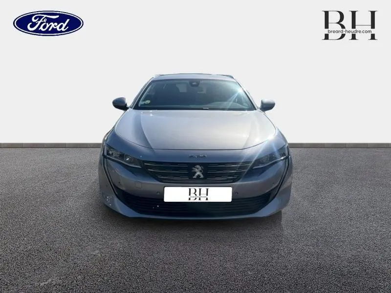 Vue de face d'une Peugeot 508 SW gris Artense avec calandre noire et logo lion central visible.