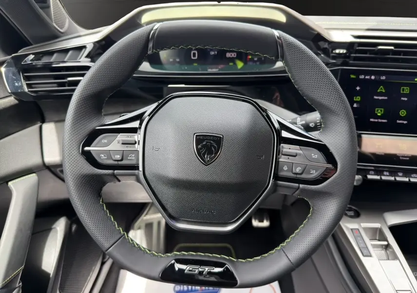 Volant GT en cuir noir avec surpiqûres vert Adamite, tableau de bord numérique 10'' et console centrale moderne de la Peugeot 308 2026.