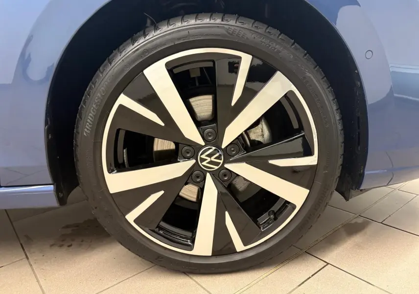 Gros plan sur la jante alliage 18'' Catania bicolore noir et argent du Volkswagen Golf Bleu Anémone côté gauche.