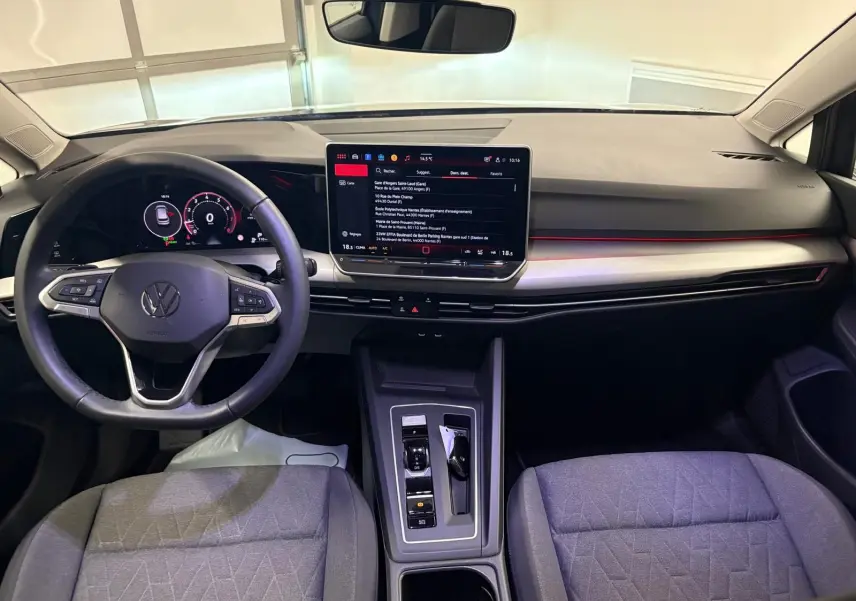 Vue intérieure avant de la Volkswagen Golf 1.5 eTSI 116 DSG7 avec tableau de bord numérique et écran tactile central.